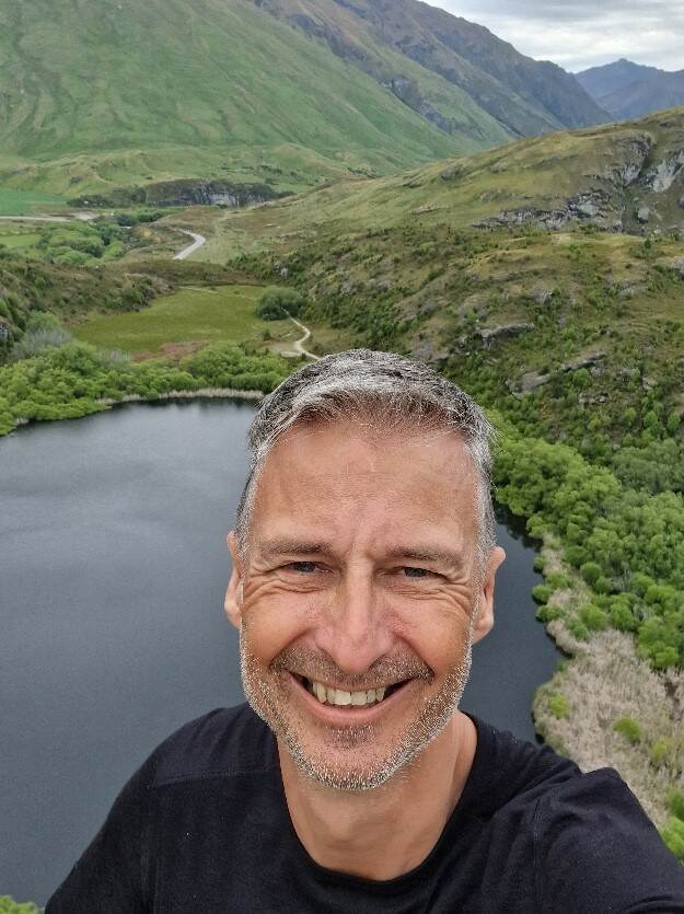 Portretfoto van Nico met natuur op de achtergrond