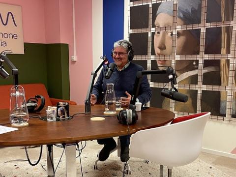 Een foto van een man met koptelefoon tijdens de opname van de podcast De Wettenfabriek